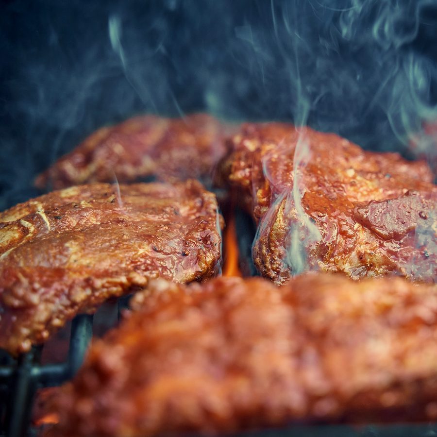 Sauced pork steaks over the flames