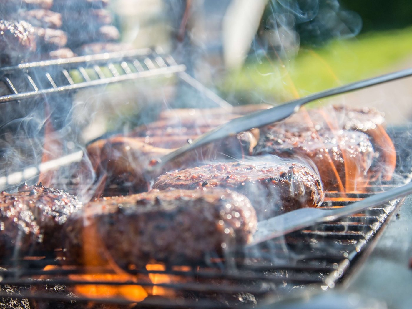 Burgers and sausages on a smoking grill