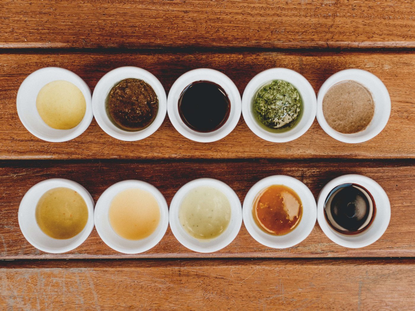 Bowls of sauces and rubs on a wooden table